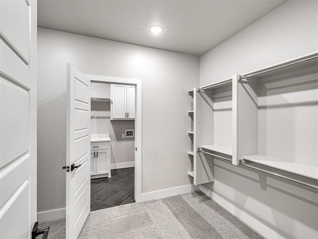 walk in closet featuring dark colored carpet