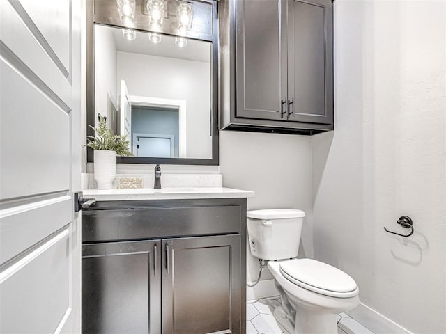 half bathroom featuring baseboards, toilet, and vanity