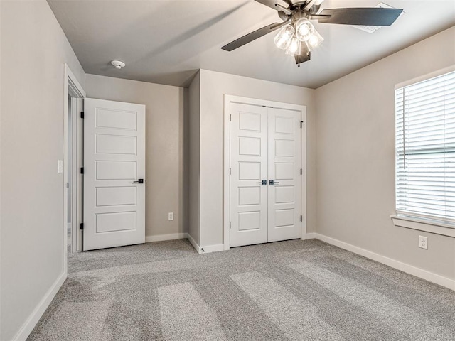 unfurnished bedroom featuring a closet, ceiling fan, baseboards, and carpet floors