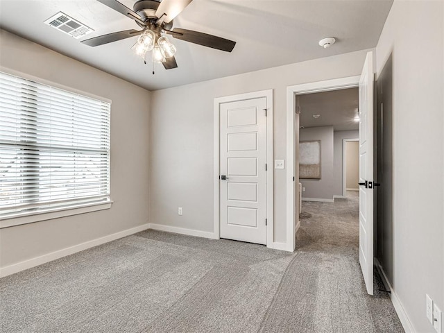 unfurnished bedroom with visible vents, baseboards, a ceiling fan, and carpet flooring