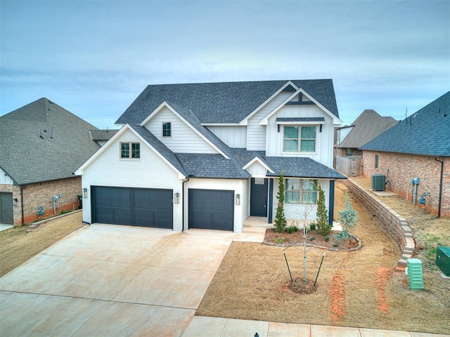 view of front of house with fence, an attached garage, a shingled roof, concrete driveway, and board and batten siding