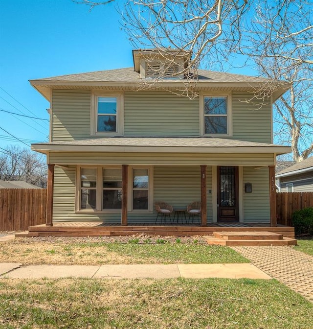 american foursquare style home featuring covered porch and fence