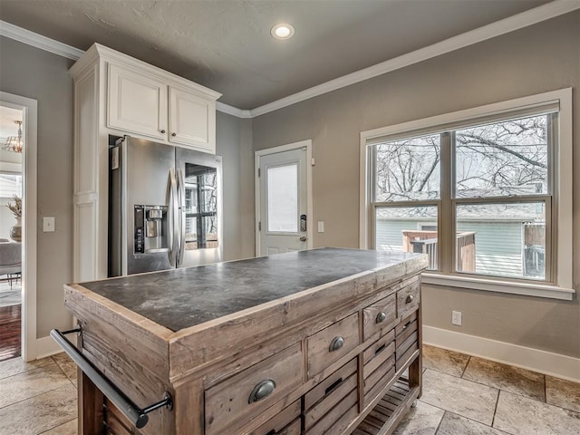 kitchen featuring stainless steel fridge, white cabinets, crown molding, and baseboards