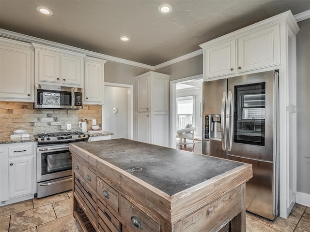 kitchen featuring stainless steel appliances, stone tile flooring, decorative backsplash, and white cabinetry