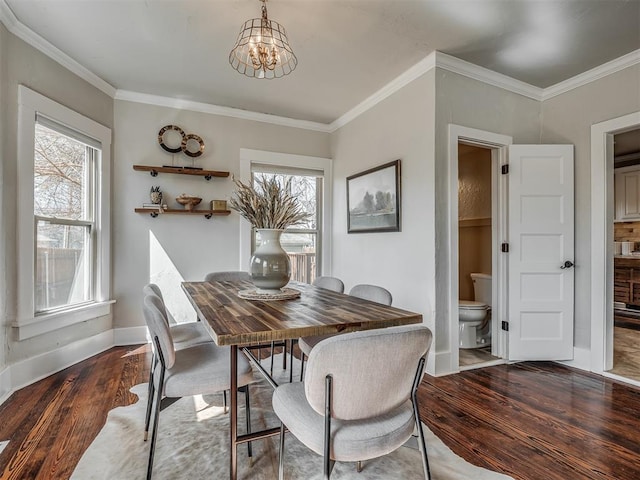 dining area featuring an inviting chandelier, crown molding, wood finished floors, and a wealth of natural light