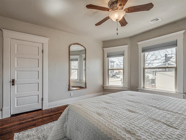 bedroom featuring a ceiling fan, dark wood-type flooring, baseboards, and visible vents