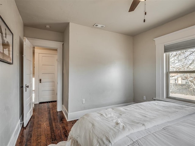 bedroom featuring visible vents, baseboards, wood finished floors, and a ceiling fan