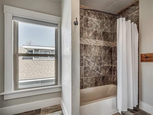 full bathroom featuring baseboards and shower / bath combo