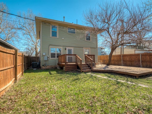 rear view of property featuring a wooden deck, a yard, central AC unit, and a fenced backyard