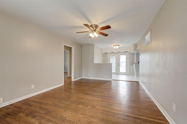 unfurnished room featuring wood finished floors, visible vents, baseboards, ceiling fan, and french doors