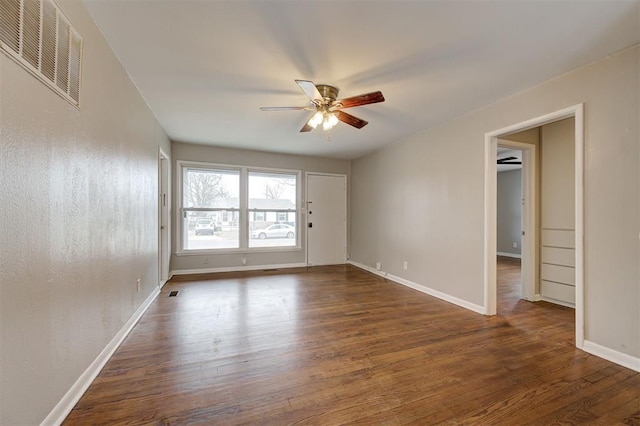 spare room featuring visible vents, wood finished floors, baseboards, and ceiling fan