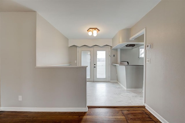 entrance foyer featuring wood finished floors, french doors, and baseboards