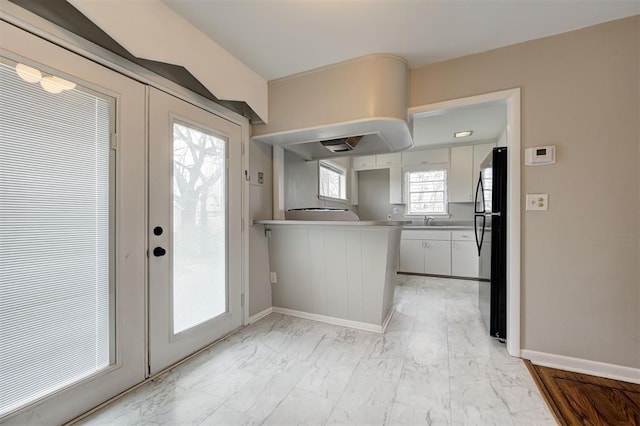 entryway with marble finish floor, french doors, and baseboards