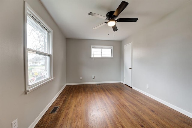 unfurnished room featuring visible vents, baseboards, a ceiling fan, and dark wood-style flooring