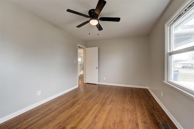 unfurnished room featuring visible vents, plenty of natural light, and baseboards