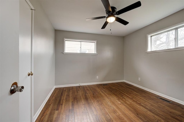 spare room featuring hardwood / wood-style floors, a healthy amount of sunlight, baseboards, and a ceiling fan