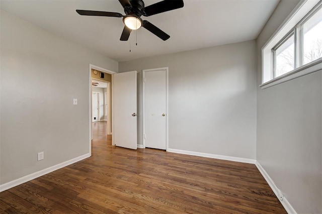 unfurnished bedroom with wood finished floors, baseboards, and ceiling fan