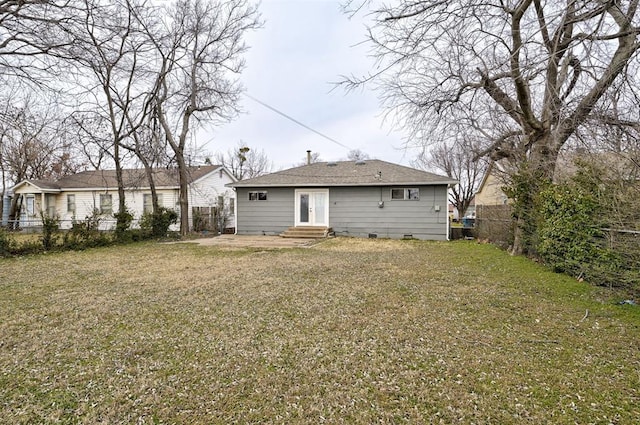 back of house with crawl space, a lawn, a fenced backyard, and entry steps