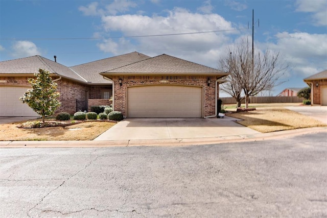 view of front of house with fence, driveway, roof with shingles, an attached garage, and brick siding