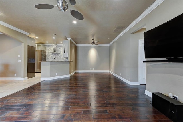 unfurnished living room featuring wood finished floors, a ceiling fan, visible vents, and ornamental molding