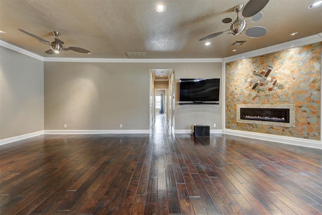 unfurnished living room with hardwood / wood-style floors, visible vents, a glass covered fireplace, and a ceiling fan