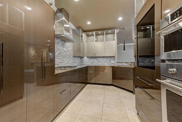 kitchen featuring modern cabinets, tasteful backsplash, appliances with stainless steel finishes, exhaust hood, and light tile patterned flooring