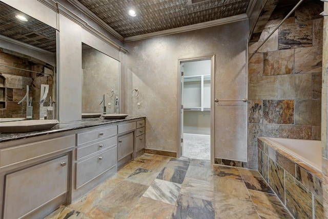 bathroom with stone tile floors, a sink, double vanity, and ornamental molding