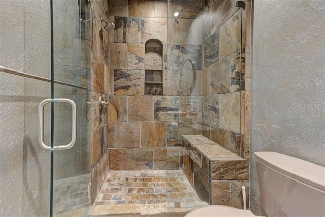 bathroom with a shower stall and toilet