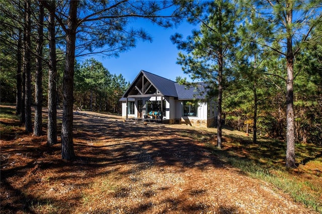 view of front of property featuring dirt driveway and metal roof