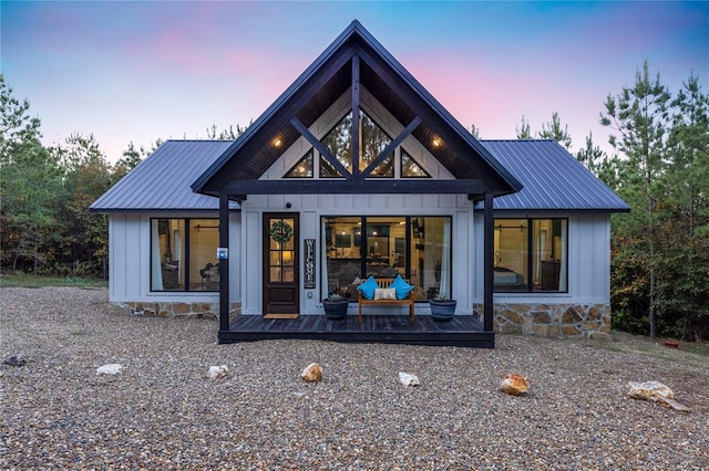 exterior space with board and batten siding and metal roof