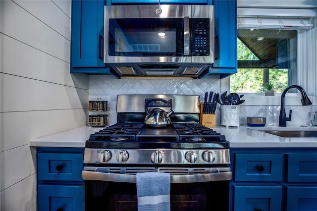 kitchen with a sink, light countertops, blue cabinetry, and stainless steel appliances