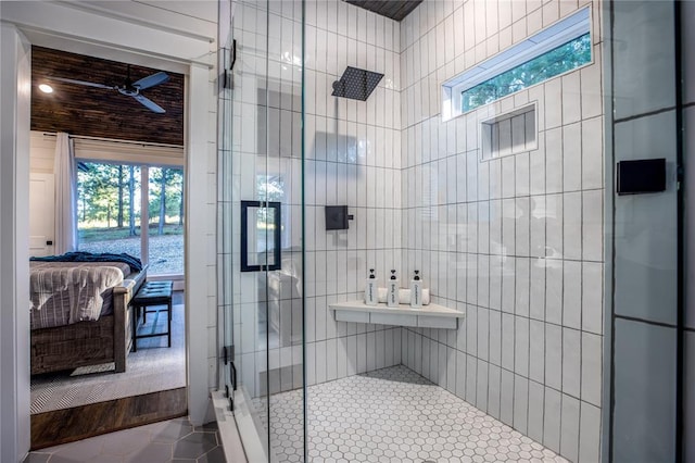 ensuite bathroom featuring tile patterned flooring, connected bathroom, a stall shower, and tile walls