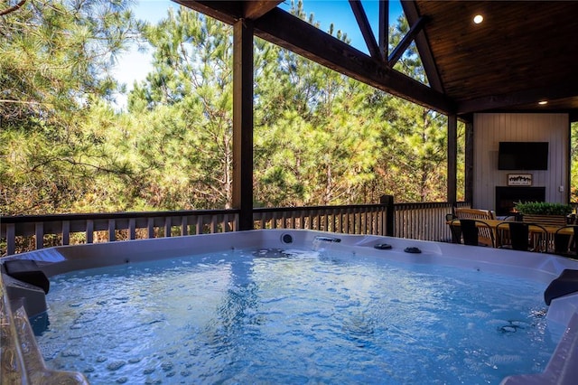 deck featuring a large fireplace and a hot tub