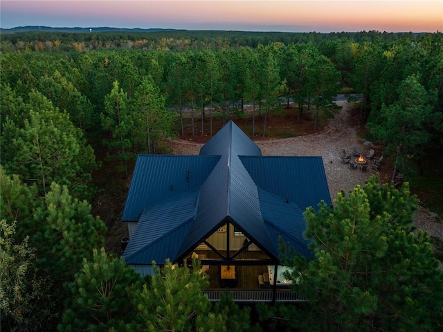 aerial view at dusk featuring a view of trees