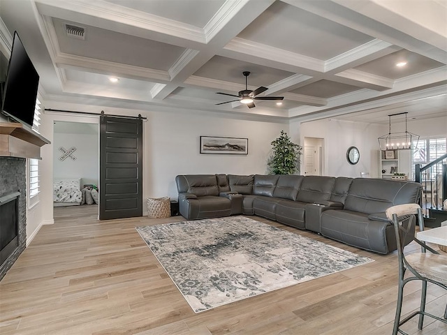 8800 Stark St, Arcadia, OK 73007 - living area with a barn door, a ceiling fan, coffered ceiling, a stone fireplace, and light wood-style floors