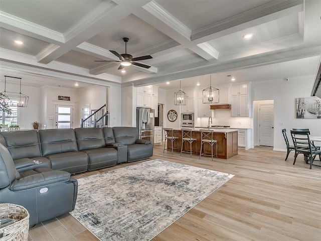 8800 Stark St, Arcadia, OK 73007 - living area with light wood-style floors, beamed ceiling, ceiling fan, crown molding, and coffered ceiling