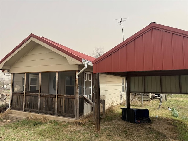 back of property featuring a carport and a sunroom