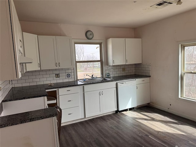 kitchen featuring visible vents, dark wood finished floors, white dishwasher, a sink, and white cabinetry