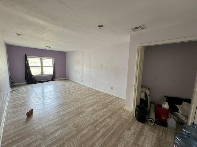 empty room with visible vents, baseboards, and wood finished floors
