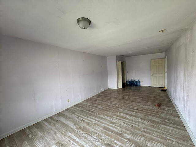 unfurnished room with baseboards and wood finished floors
