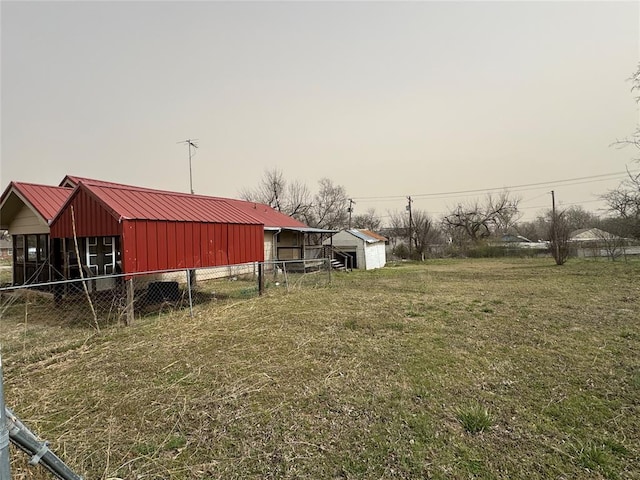 view of yard featuring an outbuilding and fence