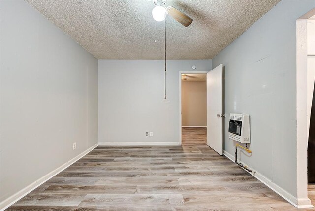 3333 S Walker Ave, Oklahoma City, OK 73109 - empty room featuring baseboards, wood finished floors, heating unit, a textured ceiling, and a ceiling fan