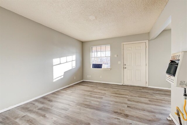 3333 S Walker Ave, Oklahoma City, OK 73109 - interior space featuring heating unit, wood finished floors, baseboards, and a textured ceiling