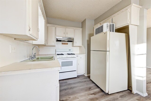 3333 S Walker Ave, Oklahoma City, OK 73109 - kitchen featuring white appliances, light wood-style flooring, a sink, under cabinet range hood, and a textured ceiling