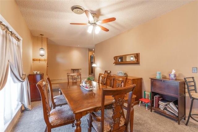 dining room featuring carpet flooring, a textured ceiling, and ceiling fan