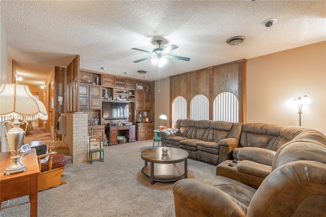 carpeted living area featuring a textured ceiling and ceiling fan