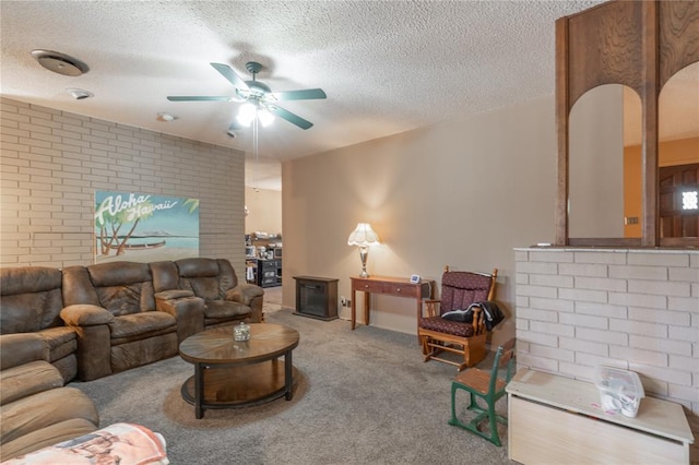 living room featuring carpet flooring, a ceiling fan, brick wall, and a textured ceiling