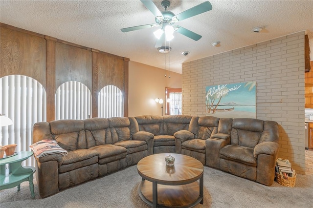 carpeted living area with wood walls, brick wall, a textured ceiling, and a ceiling fan