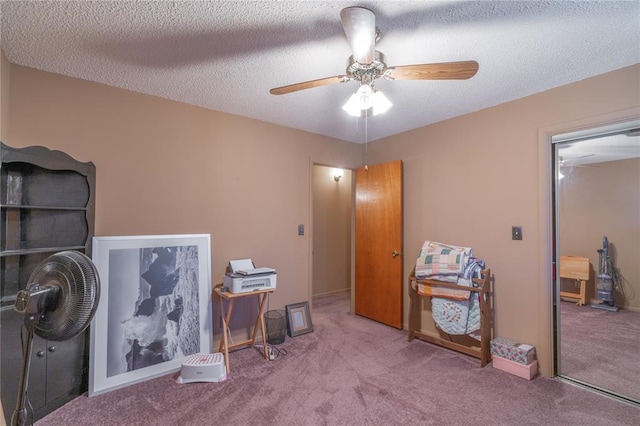 misc room featuring carpet floors, a textured ceiling, and ceiling fan