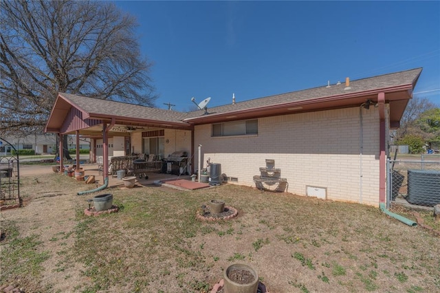 back of house featuring a patio, central AC, crawl space, a lawn, and brick siding